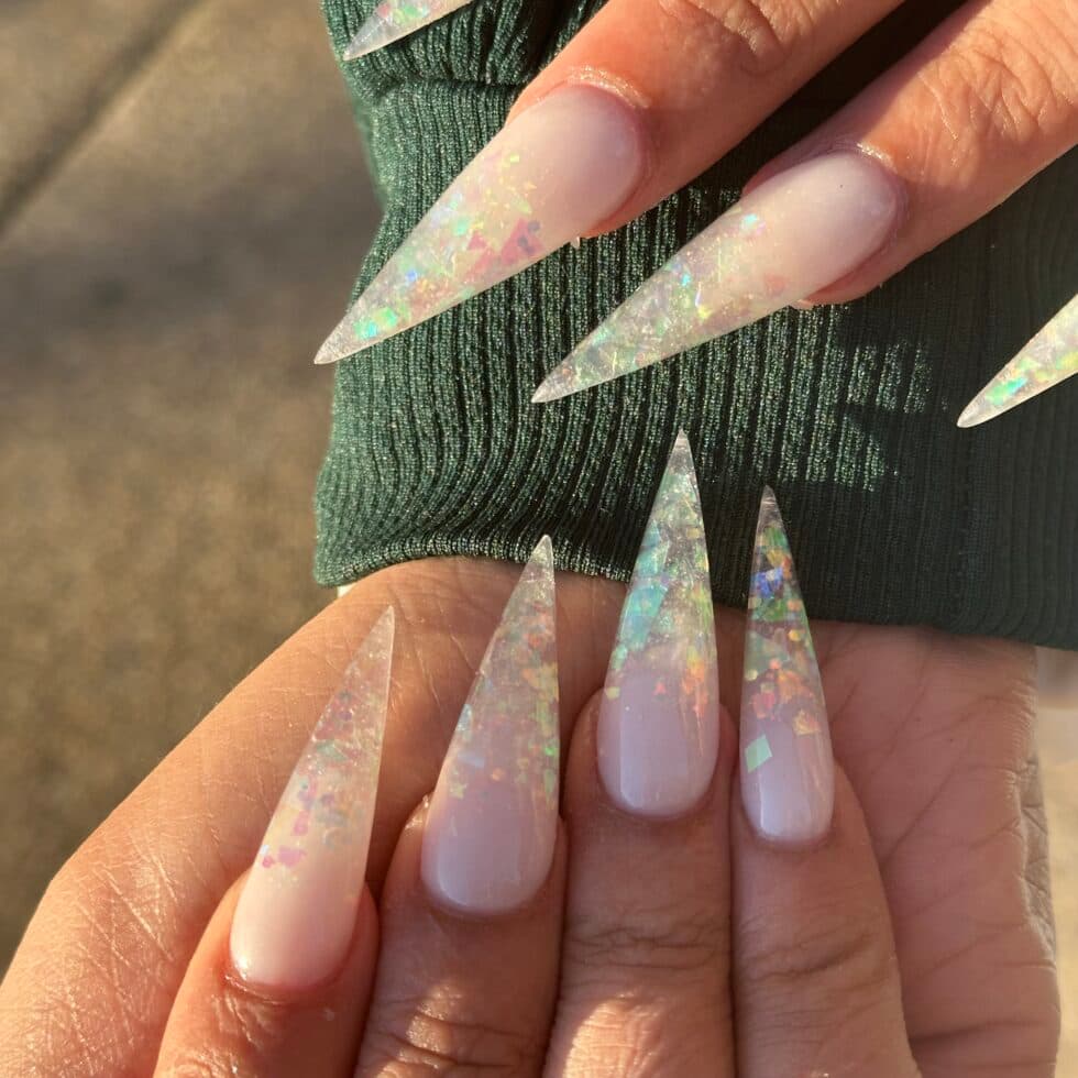 Holographic stiletto nails in warm light