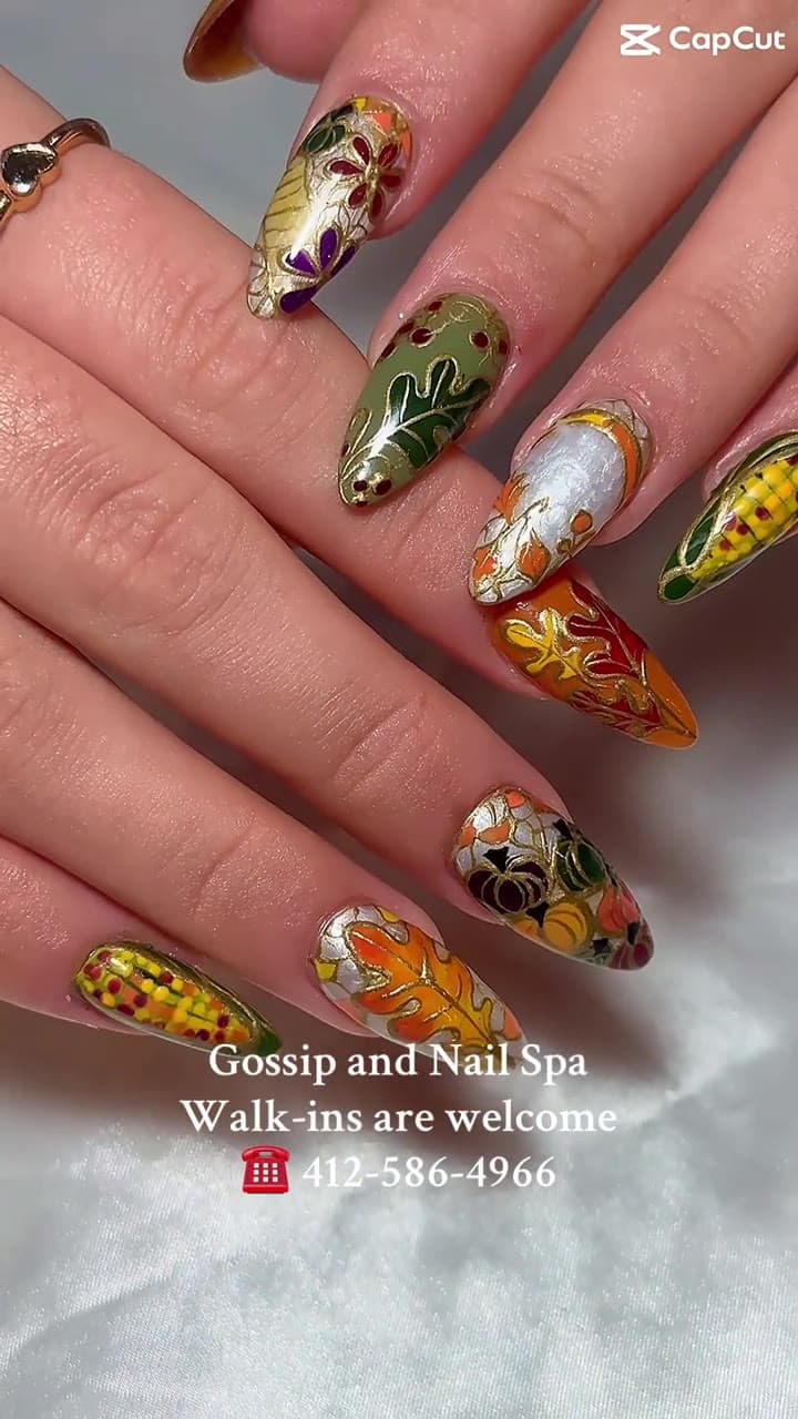 Close-up Thanksgiving nails — pumpkin, corn, and gold filigree