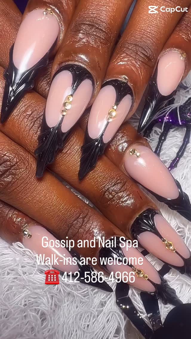 Nude stiletto nails with sculpted glossy black gothic tips and gold studs